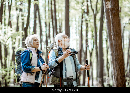 Senior paar Suche mit dem Fernglas beim Wandern im Wald. Konzept eines aktiven Lebensstils auf Ruhestand Stockfoto