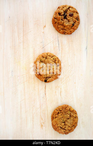 Frisches selbstgebackenes Macadamianuss und Chocolate chunk Cookies in flachen arrangiert legen Zusammensetzung auf rustikalen Holzmöbeln Hintergrund. Gesunde Ernährung Konzept. Stockfoto