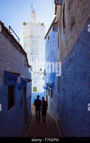 Chefchaouen, Marokko: Ein paar Spaziergänge in ein blau-Gasse unter dem Minarett einer Moschee in der Medina gewaschen. Stockfoto