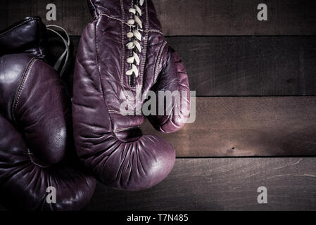 Paar vintage, antike Boxhandschuhe auf einem Braunen, leiste Holz- Hintergrund Stockfoto