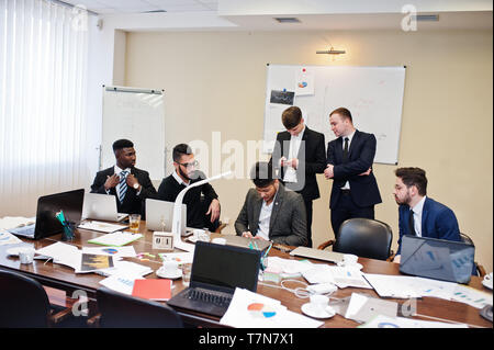 Sechs multirassischen Business mans im Büro am Tisch. Vielfältige Gruppe der männlichen Beschäftigten in formale Abnutzung zu diskutieren. Stockfoto