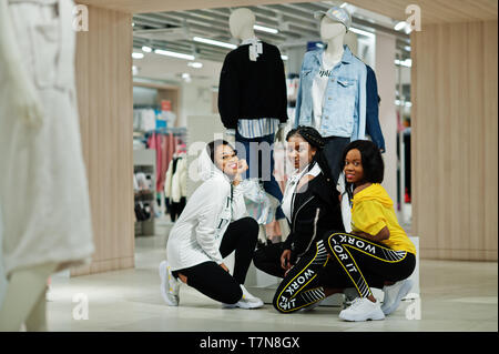 Drei afican amerikanische Frauen in Trainingsanzügen einkaufen bei Sportswear Mall gegen Schaufensterpuppe. Sport store Thema. Stockfoto