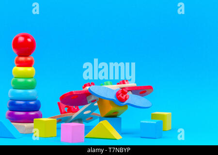 Baby Kind Spielzeug Hintergrund. Holzspielzeug, Baby stapeln Ringe Pyramide und bunte Bausteine auf blauem Hintergrund Stockfoto