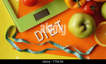 Konzept Ernährung. Gesundes Essen, Küche Waage. Gemüse und Früchte. Ansicht von oben Close-up auf orange Hintergrund Stockfoto