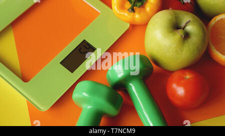 Konzept Ernährung. Gesundes Essen, Küche Waage. Gemüse und Früchte. Ansicht von oben Close-up auf orange Hintergrund Stockfoto