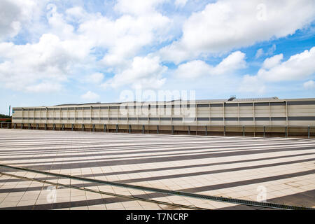 Weite Einstellung der modernen industriellen Gebäude Exterieur mit horizontalen Linien und blauer Himmel mit Wolken im Hintergrund Stockfoto