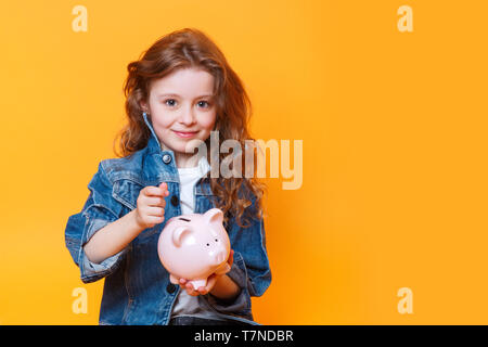 Verantwortlich kleines Mädchen Geld in das Sparschwein für die Zukunft sparen Stockfoto