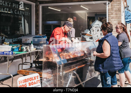 Sheringham, Großbritannien - 21 April, 2019: Frau kaufen hog Roast aus einer Street Food Markt in Sheringham, einem beliebten englischen Küstenstadt innerhalb der Graf Abschaltdruck Stockfoto