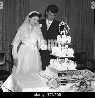 Die Hochzeit von Herrn und Frau Walker, 2 Colenso Road, London, E5c 1964. Die Braut und der Bräutigam schneiden Sie den Kuchen. Foto von Tony Henshaw Stockfoto