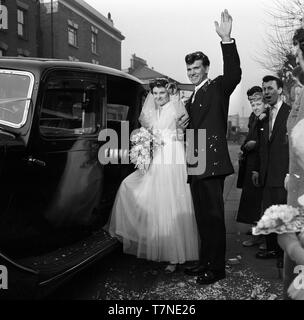 Die Hochzeit von Herrn und Frau Walker, 2 Colenso Road, London, E5c 1964. Braut und Bräutigam lassen für die Rezeption. Foto von Tony Henshaw Stockfoto