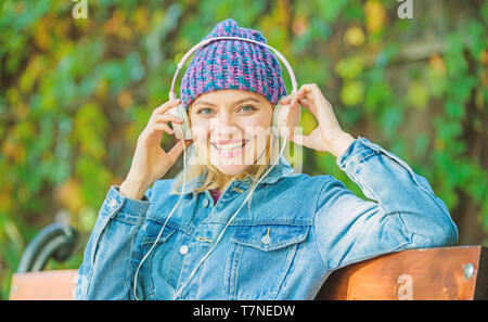 Leute Hörbücher vom mobilen Gerät und Computer anhören. Moderne Technik statt lesen. Hörbuch. Musik im Park anhören. hipster Mädchen mit mp3-Player. hipster Frau in Kopfhörer. Stockfoto