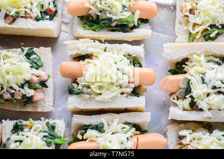 Spinat überbacken mit Käse, Wurst auf Baguette, Französisches Brot Stockfoto