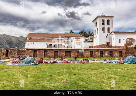 Chinchero, Peru - April 4, 2019: Central Plaza vor der Kirche in Chinchero, Peru. Lokale Frau Verkauf von traditionellen Peruanischen handicra Stockfoto