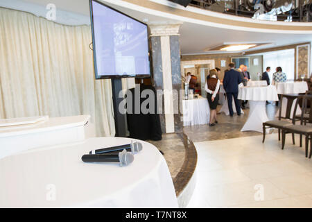 Belarus, die Stadt Gomel, 26. Februar 2019. Business Konferenz der Bank.. Konzept Präsentation. Leerer Bildschirm Mikrofone auf dem Tisch Stühle Stockfoto