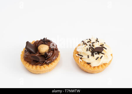 Einige Runden Gebäck mit schwarzen und weißen Creme auf eine weiße Fläche Stockfoto