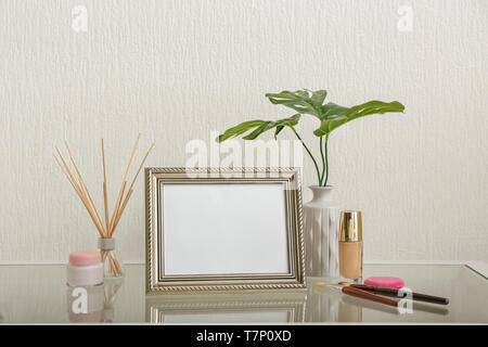 Zusammensetzung mit Bilderrahmen auf Glas Tisch gegen hellen Hintergrund Stockfoto