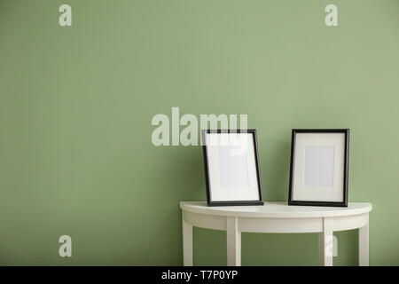 Bilderrahmen auf weißen Tisch gegen Farbe Hintergrund Stockfoto