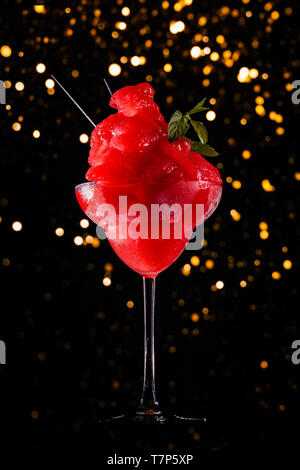 Frozen strawberry Margarita auf dem dunklen Hintergrund mit festliche Bokeh. Luxus Handwerk trinken Konzept. Vertikale Stockfoto