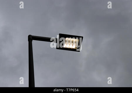 LED Street Lamp Post glühende auf dunklen bewölkter Himmel Hintergrund. Led-Leuchten in Abend, Einsparung von elektrischer Energie Stockfoto