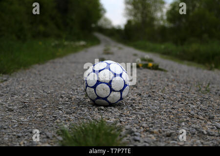 Alte Fußball-Ball liegt auf der Straße. Stockfoto