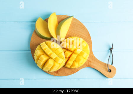 Schneidbrett mit Cut reife Mangos auf farbigen Hintergrund, Ansicht von oben Stockfoto