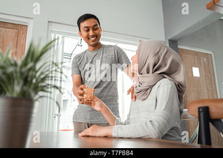 Mann zu trinken zu seiner Frau Stockfoto