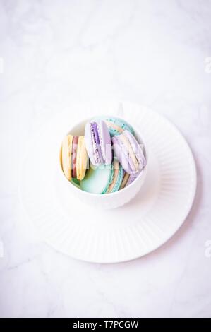 Süßen, bunten Pastelltönen französische Makronen oder Macaron auf weißem Hintergrund. Ansicht von oben, kopieren Raum Stockfoto