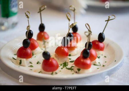 Speisen in Buffetform. Scheiben Käse mit Cherry Tomaten und Oliven Stockfoto