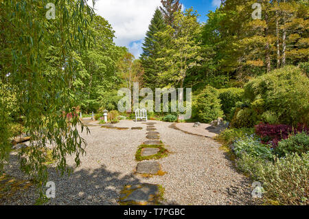 ATTADALE GÄRTEN STRATHCARRON WESTER ROSS SCHOTTLAND IM FRÜHJAHR TRITTSTEINE ÜBER DEN KIES IN DEN JAPANISCHEN GARTEN. Stockfoto