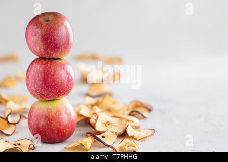 Stapel von drei frische Äpfel und Sonne getrocknet Apfel Chips als gesunder Snack Stockfoto