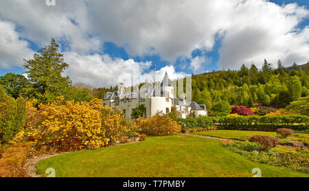 ATTADALE GÄRTEN STRATHCARRON WESTER ROSS SCHOTTLAND DAS HAUS IM FRÜHLING mit Rasen gelb Azaleen und von Bäumen gesäumten Hügel Stockfoto