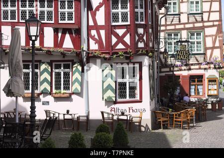 Bacharach, Deutschland - 25 April 2019: Ein Fachwerkhaus mit Tischen und Stühlen im Garten Stockfoto