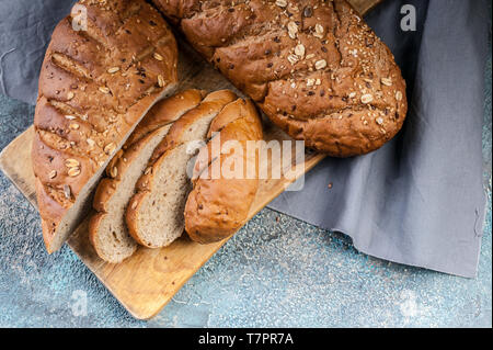 Müsli Brötchen mit verschiedenen Samen auf einer hölzernen Schneidebrett. Ansicht von oben Stockfoto