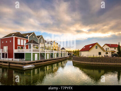 Niederländisch, modernen, farbenfrohen vinex Architektur Häuser am Wasser während der dramatischen und bewölkt, Sonnenuntergang. Houten, Utrecht. Stockfoto