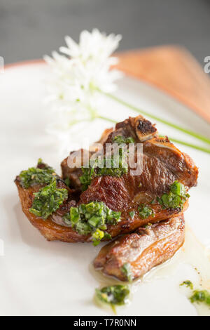 Zwei gekocht Britischen Lammkoteletts gekauft von einem Supermarkt, die in Olivenöl gebraten wurden. Sie wurden mit Olivenöl, Salz, Pfeffer, Zitrone gekleidet Stockfoto