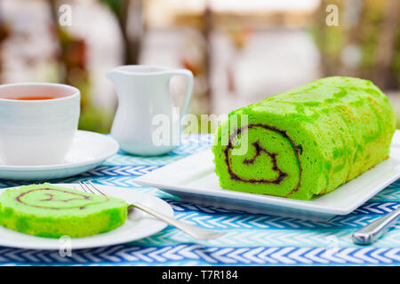 Grüne roll Kuchen mit einer Tasse Kaffee. Außenpool im Sommer Hintergrund. Kopieren Sie Platz. Stockfoto