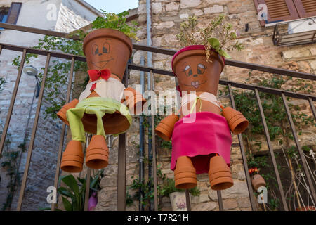 Spello, Umbrien, Italien, September 5, 2017: Zwei süße Flower Pot Zeichen wie ein Mann und eine Frau zu einem metallgeländer in einem kleinen italienischen Dorf gebunden gekleidet Stockfoto