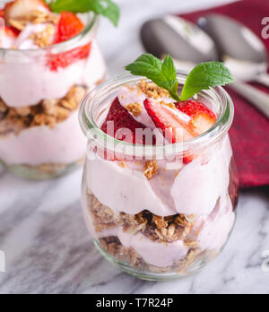 Nahaufnahme von einem Parfait mit Joghurt, Müsli und frischen Erdbeeren im Glas gemacht Stockfoto