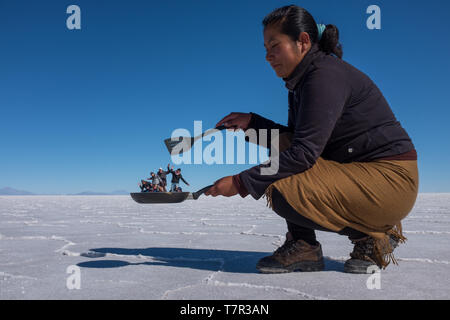 Uyuni, Bolivien, Juni, 11, 2015: ein sehr sonderbares prospektive Schuß am Uyuni Salzwüste wie dieser Koch schaut, wie sie Touristen in ihrer Pfanne, Salinen, Bolivien gegen einen strahlend blauen Himmel hat Stockfoto