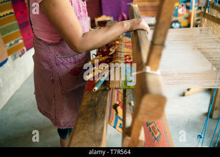 Frau weben eine Wolldecke auf ein Pedal Webstuhl. Teotitlan del Valle, Oaxaca, Mexiko. Apr 2019 Stockfoto