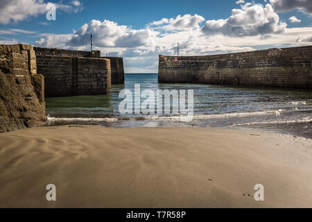 Betrachten Sie auf den Eingang von Charlestown Hafen in Cornwall, England, Schuß aus dem Sand, gegen einen strahlend blauen Himmel Stockfoto