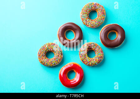 Auswahl an Donuts auf blauem Hintergrund. Kopieren Sie Platz. Ansicht von oben. Stockfoto