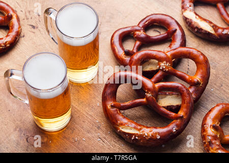 Bier und gesalzene Brezeln auf hölzernen Tisch Hintergrund. Close Up. Stockfoto