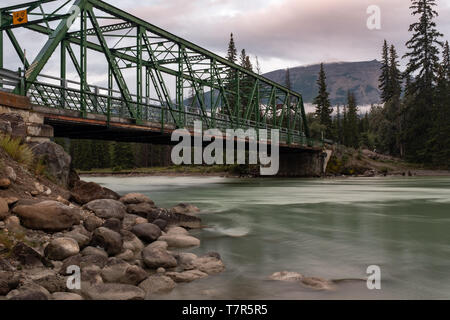 Eine grüne Eisen Brücke über den Athabasca River im Jasper Nationalpark, Gewässer sind glatt durch lange Belichtung Stockfoto