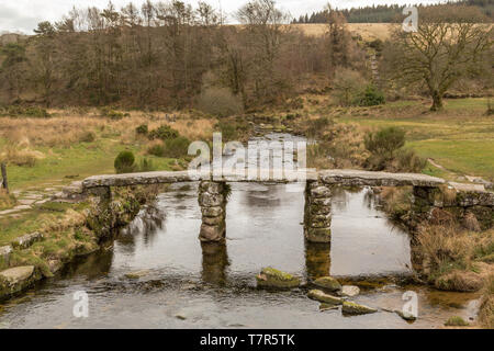 Eine Front auf Schuß des historischen Clapper Bridge aus Granit und die East Dart River Crossing in Dartmoor National Park, England Stockfoto