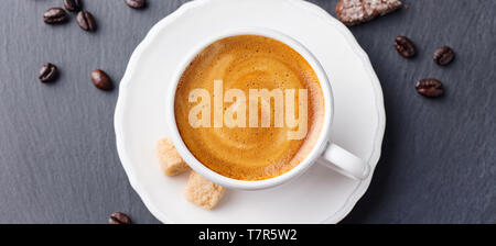 Kaffee Espresso in weiße Tasse mit schwarzem Schiefer Hintergrund. Ansicht von oben. Stockfoto