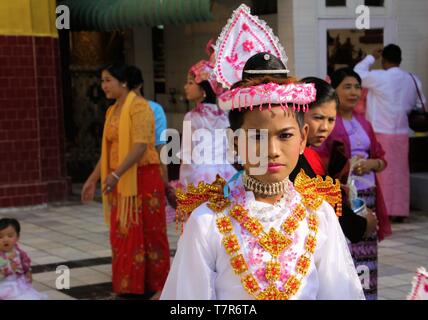 MANDALAY, MYANMAR - Dezember 18. 2015: Novitiation (Noviziat) Zeremonie (Shinbyu) für junge buddhistische Junge mit Make-up und Lippenstift bei Maha Muni Pagode Stockfoto