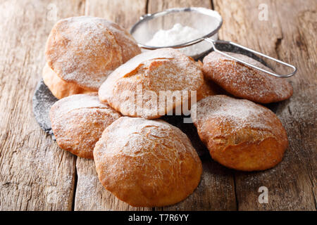 Bunuelos hausgemachten Krapfen mit Puderzucker bestreut Close-up auf dem Tisch. Horizontale Stockfoto