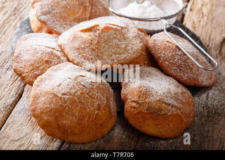 Pupular Street Food Bunuelos bestreut mit Puderzucker close-up auf dem Tisch. Horizontale Stockfoto