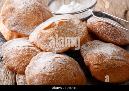 Traditionelle frittierte Teig Bunuelos bestreut mit Puderzucker close-up auf dem Tisch. Horizontale Stockfoto